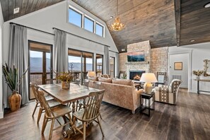 A spacious living area with a fireplace, dining table, and seating.