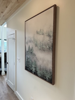A hallway with a large framed artwork depicting a forest scene. - New cabin/chalet with amentities in Sevierville. Just 5 minutes from Wilderness. (Sevierville)