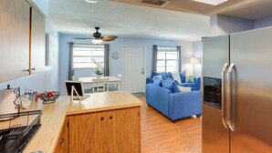 Eine moderne Küche mit einer Holz-Kochinsel, einem blauen Sofa und einem Edelstahl-Kühlschrank.