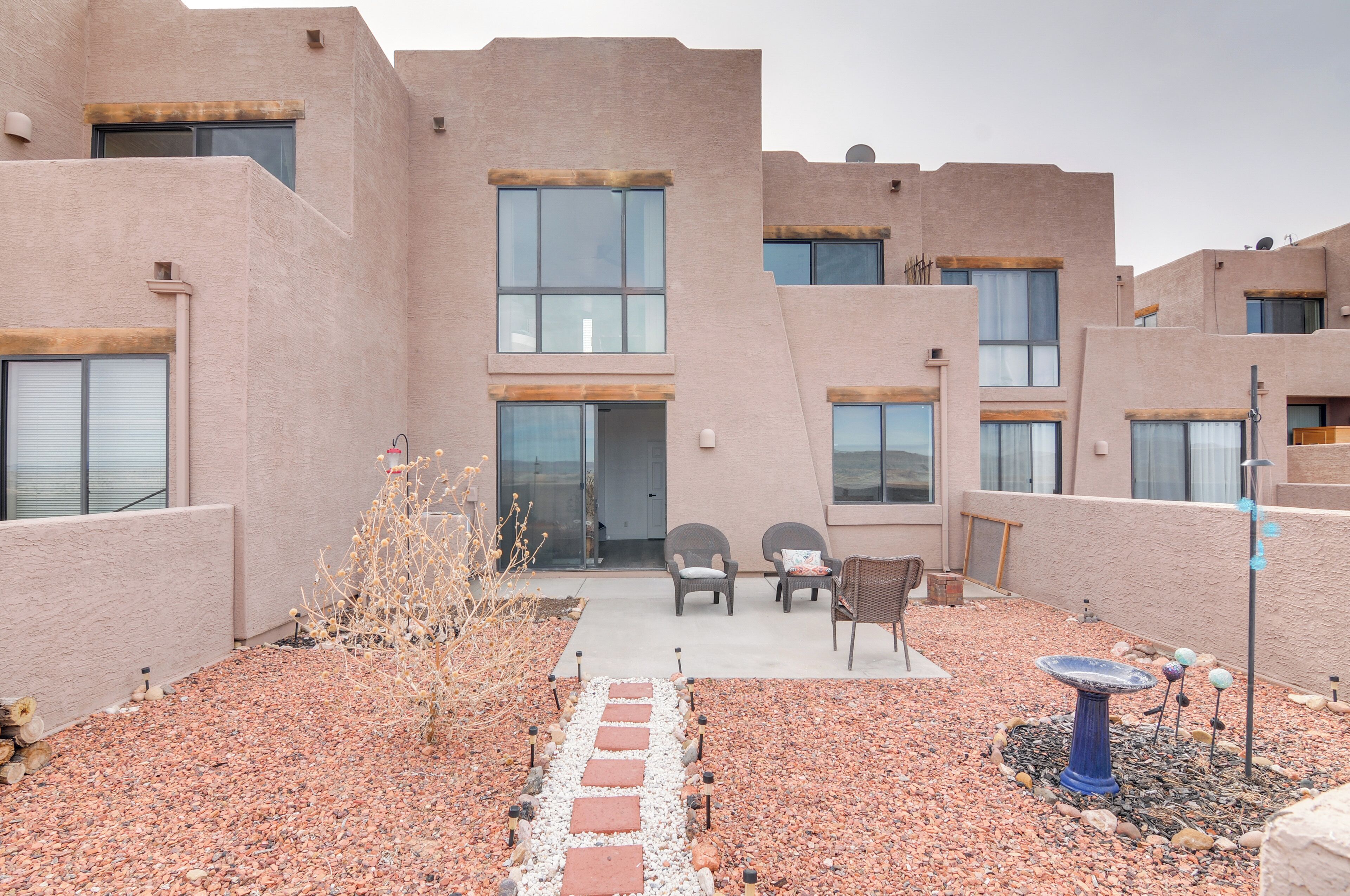 A building with a modern design, featuring large windows and a patio area with outdoor seating.