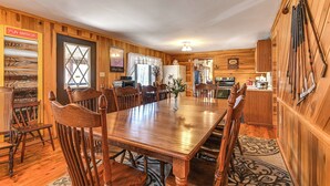 A wooden dining room with a large table and chairs, a kitchen area with wooden cabinets, and a mirror labeled "Fun Mirror". - Cozy Mount Union Cabin w/ Fire Pit & River Access (Mount Union)