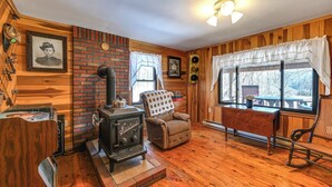 A cozy room with a wood stove, a rocking chair, and a bench. - Cozy Mount Union Cabin w/ Fire Pit & River Access (Mount Union)