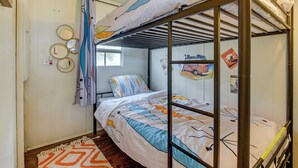 A bunk bed room with a window, a patterned rug, and wall decorations. - Pet-friendly Brownwood Home: Walk to Lake! (Brownwood)