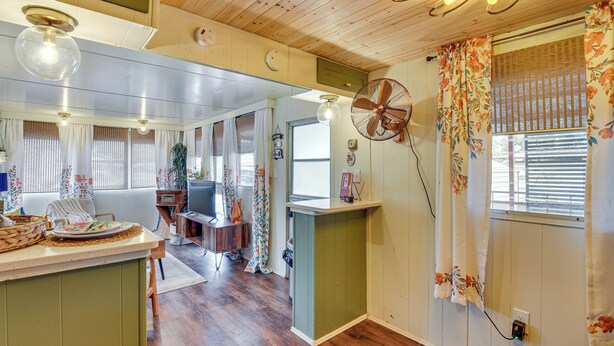 A cozy, well-lit room with wooden floors, a dining area with a table and chairs, and a kitchen counter. - Pet-friendly Brownwood Home: Walk to Lake! (Brownwood)