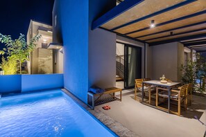Eine moderne Außenpatio mit Pool, Esstisch und Stühlen.