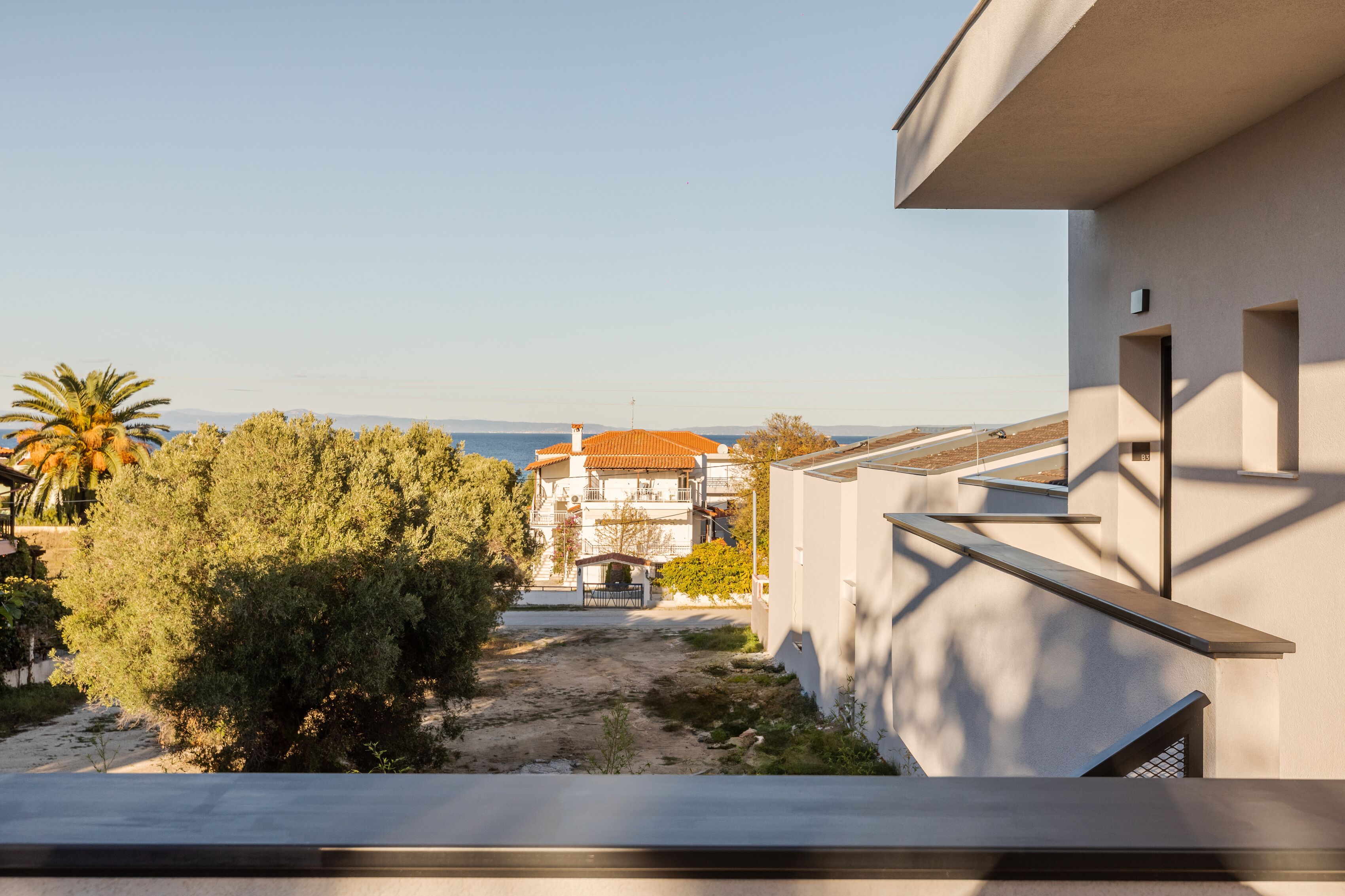 A modern building with a balcony overlooking a beach.