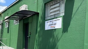Ein grünes Gebäude mit einem Schild, das es als Hostel in São João kennzeichnet.