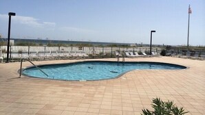 A swimming pool with lounge chairs and a flagpole. - Surf Side Shores 1206  New Sofa   3 bd / 3 bth gulf-front corner unit (Gulf Shores)