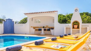 A pool area with lounge chairs, a small bar, and a pergola. - Villa Renaissance (Lagoa)
