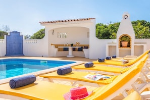 A pool area with lounge chairs, a small bar, and a pergola. - Villa Renaissance (Lagoa)