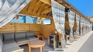 Eine Holzkonstruktion mit einer Couch, einem kleinen Tisch und einem Fernsehbildschirm.