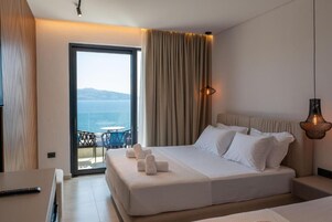 Una habitación de hotel con cama, escritorio y vista al mar.