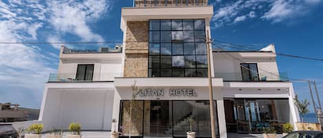 Un hotel moderno con una entrada destacada, ventanas amplias y fachada de piedra.