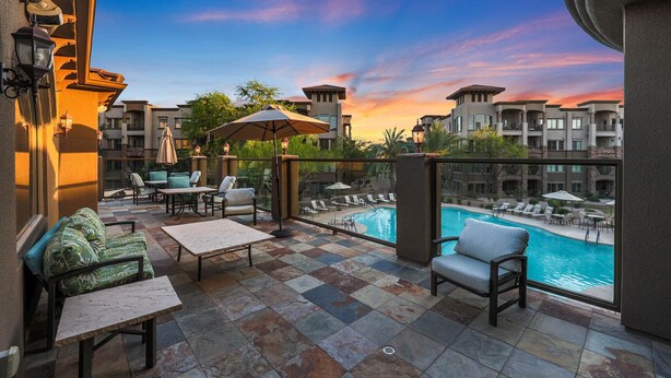 A balcony with outdoor seating, a pool, and a view of other buildings. - Location, Luxury Amenities, Walk to everything! (Phoenix)