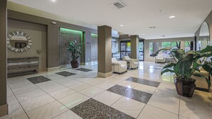 A spacious lobby with a reception desk, seating area, and large windows. - Location, Luxury Amenities, Walk to everything! (Phoenix)