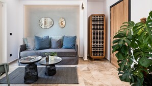 A modern living room with a grey sofa, blue cushions, a coffee table, and a bookshelf.
