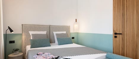 A modern bedroom with a bed, bedside tables, a lamp, and a wooden wardrobe.