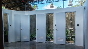A modern interior with a concrete floor, white doors, and a view of greenery outside.