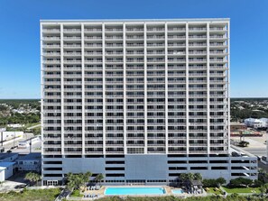 A high-rise hotel with multiple floors, a swimming pool, and a parking garage. - Ocean Reef 1108 Beachfront, Heated Indoor & Outdoor Pools, Hot Tub, FREE Golf (Panama City Beach)