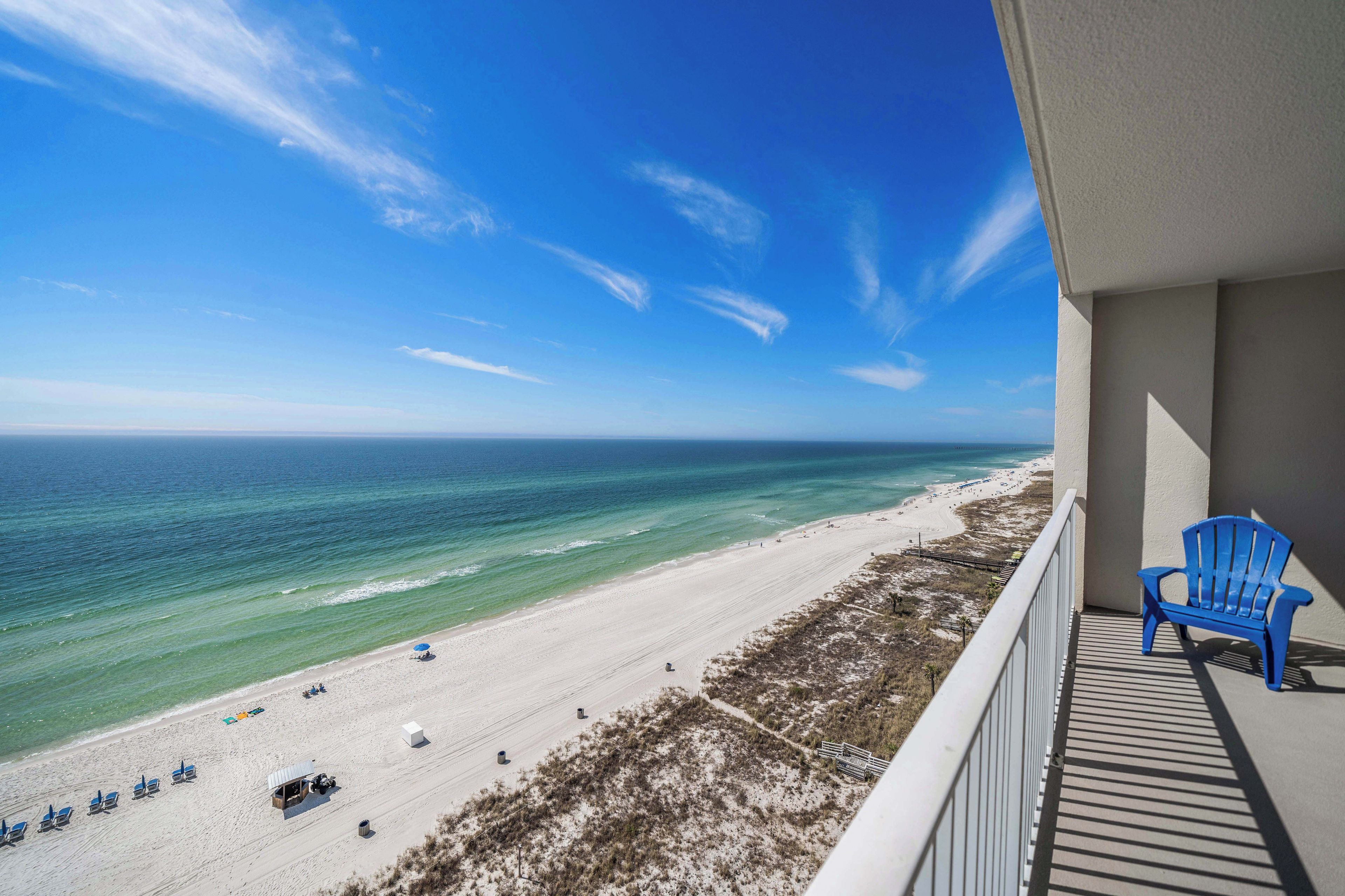 A balcony with a view of a beach and ocean.