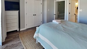 A bedroom with a bed, a dresser, and a wardrobe. - Dove's Landing | Serene Coastal Retreat + Access to Pool & More! (Surf City)