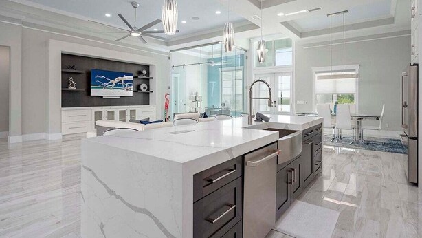 A modern kitchen with a large island, built-in appliances, and pendant lighting.