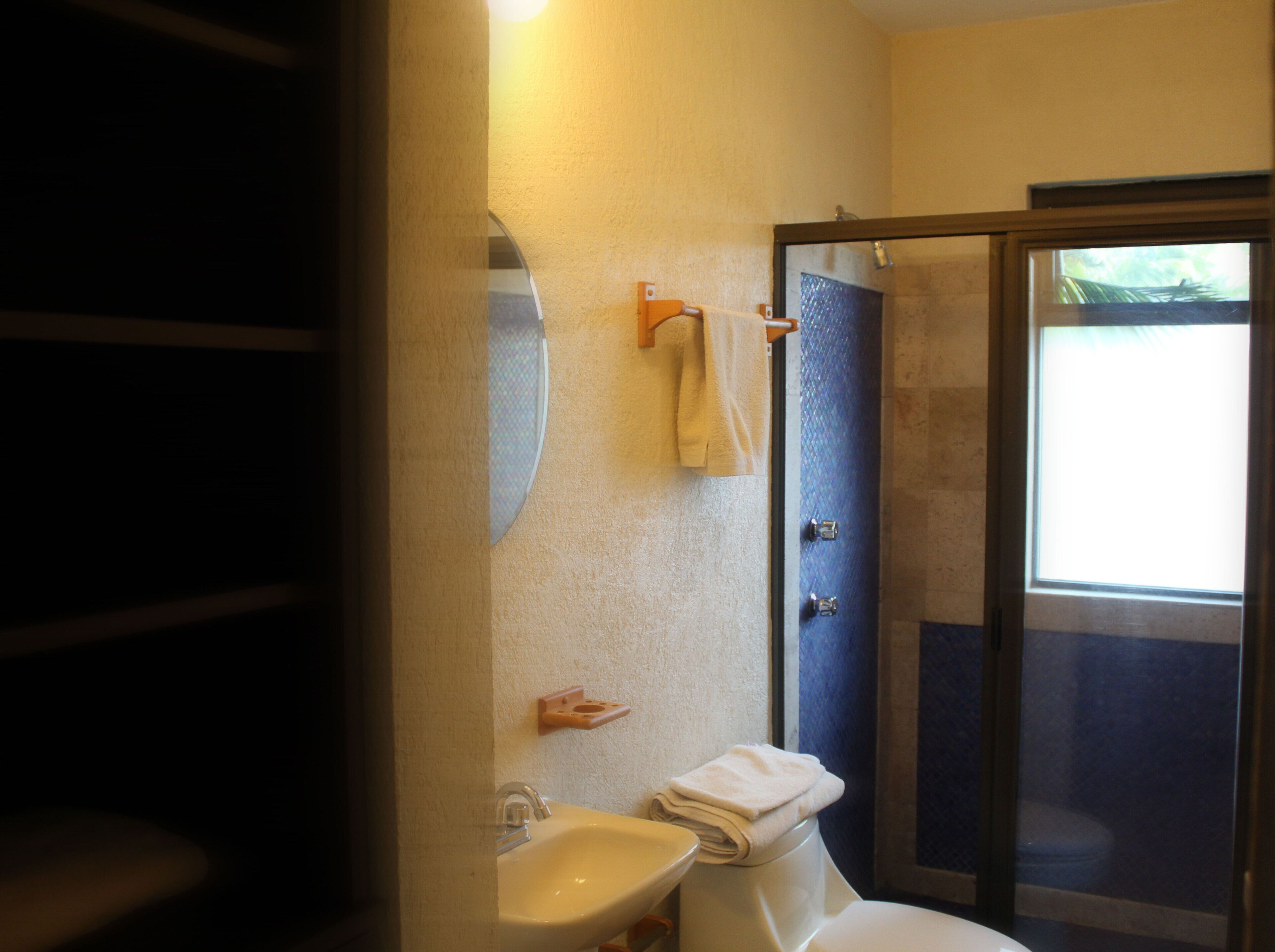 Een badkamer met een wastafel, toilet en een douchecabine van glas.