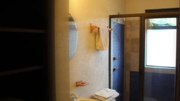 Een badkamer met een wastafel, toilet en een douchecabine van glas.