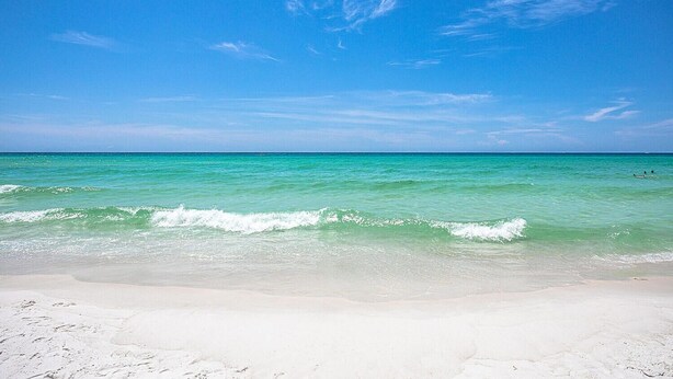 Una playa con agua turquesa cristalina y una orilla arenosa.