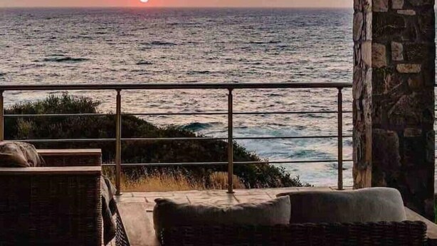 A sunset view from a balcony with stone pillars and a railing. - Villa Mediterranea – Beachside Escape for Slow Living with Private Heated Pool (Livadia)