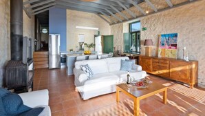 A spacious living area with a sofa set, a wooden coffee table, and a stone wall. - Villa Mediterranea – Beachside Escape for Slow Living with Private Heated Pool (Livadia)