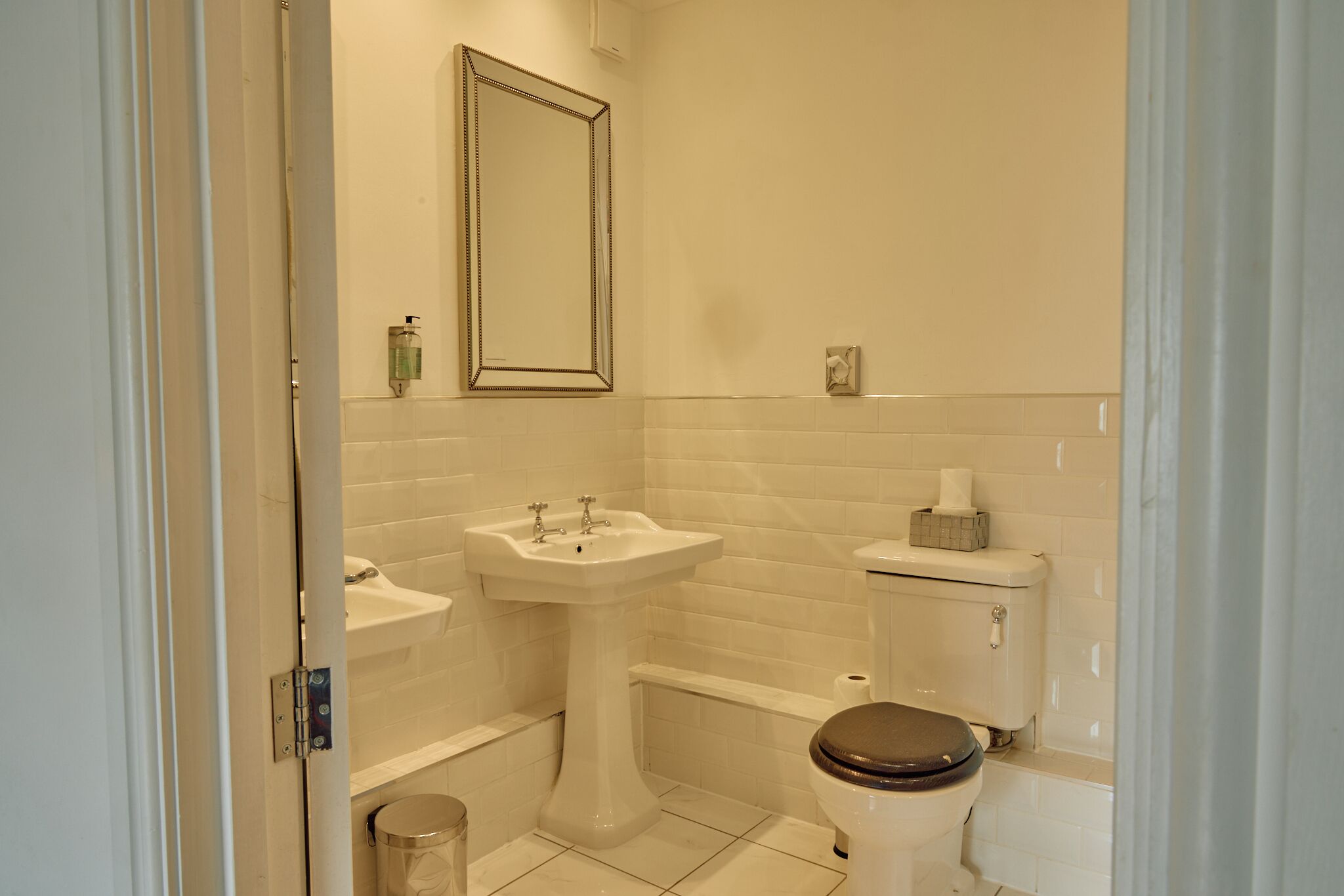 A bathroom with a sink, toilet, and mirror.