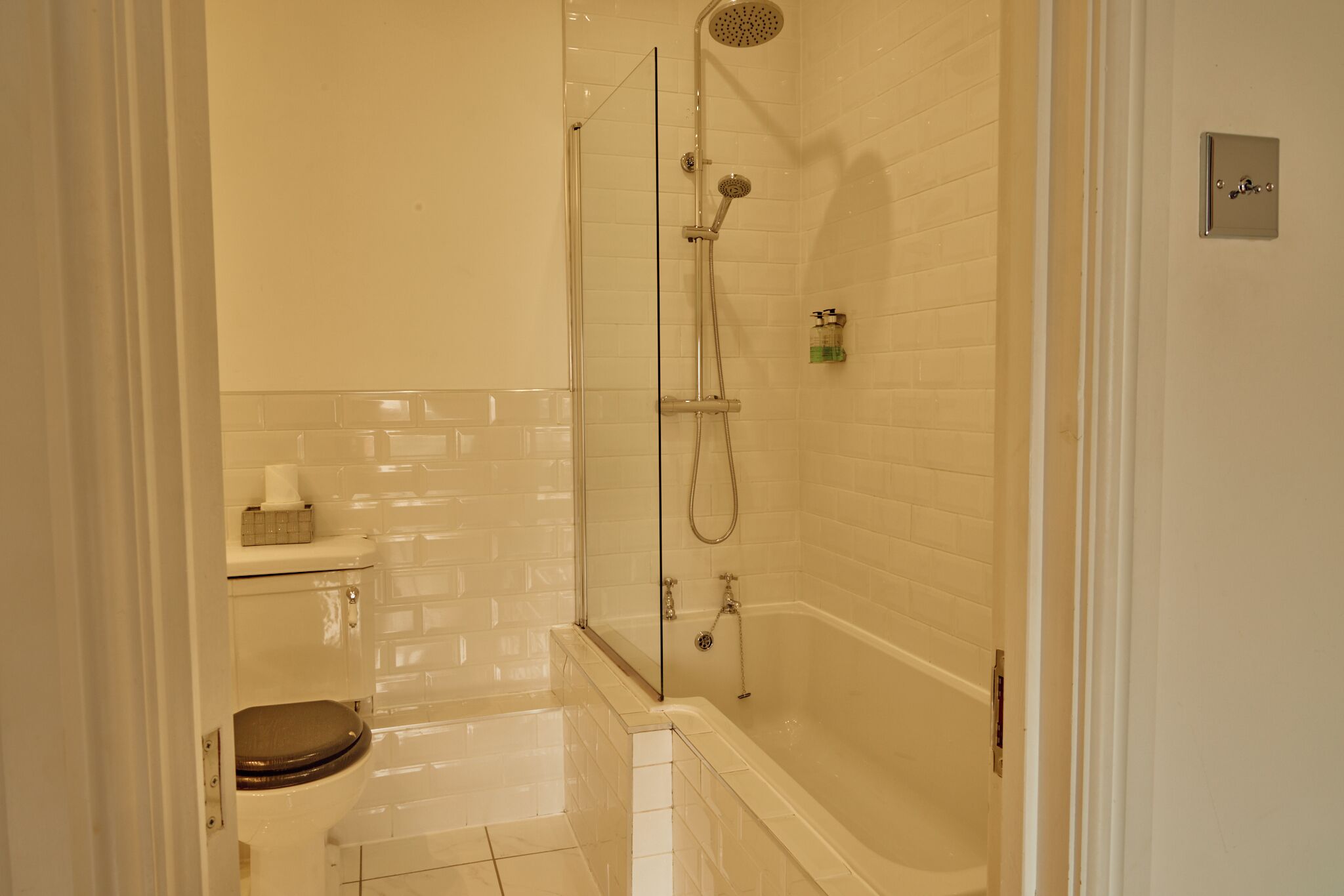 A bathroom with a glass-enclosed shower, a toilet, and a bathtub.