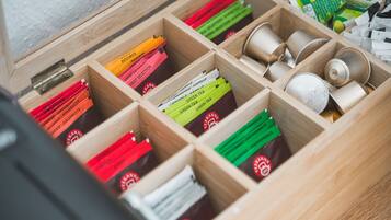 A wooden drawer with compartments containing various tea bags and tins.
