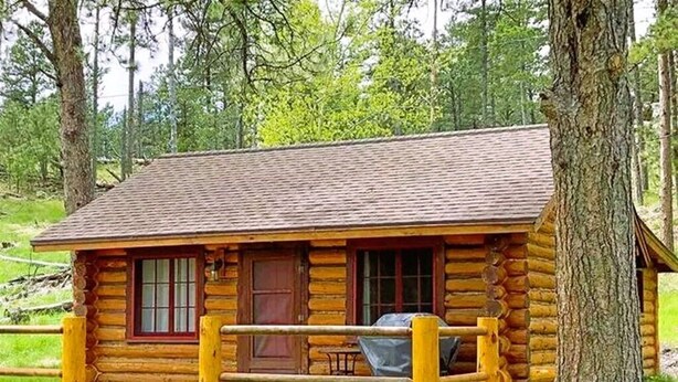A log cabin with a porch, a covered grill, and a wooden deck. - Historic Cabin next to Custer State Park, Private (Custer)