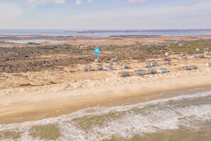 Une zone côtière comprenant de nombreuses propriétés situées en bord de mer, notamment des maisons et un grand bâtiment, probablement un hôtel ou un complexe touristique.