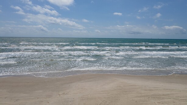 A beach with waves and a clear sky. - Throw Em Back Inn, Dog Friendly! (Port Aransas)