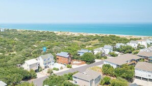 Ein Küstenwohngebiet mit Häusern, Strand und blauem Himmel.