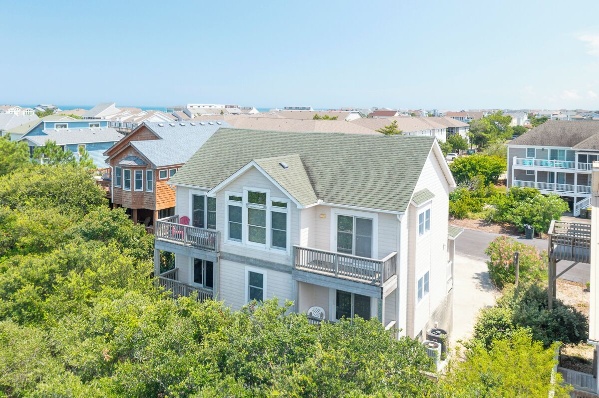 A coastal residential area with houses featuring balconies and a view of the sea.