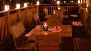An outdoor dining area with wooden furniture and a table with a candle. - Pension Les (Brežice)