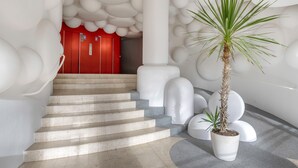 A modern interior with a staircase, white spherical columns, and a red door. - Superb balcony - Sea view - Apartment for 2 (La Baule-Escoublac)