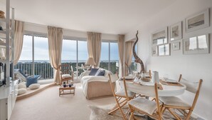 A spacious living room with a balcony, a dining area, and a bedroom with a large window. - Superb balcony - Sea view - Apartment for 2 (La Baule-Escoublac)