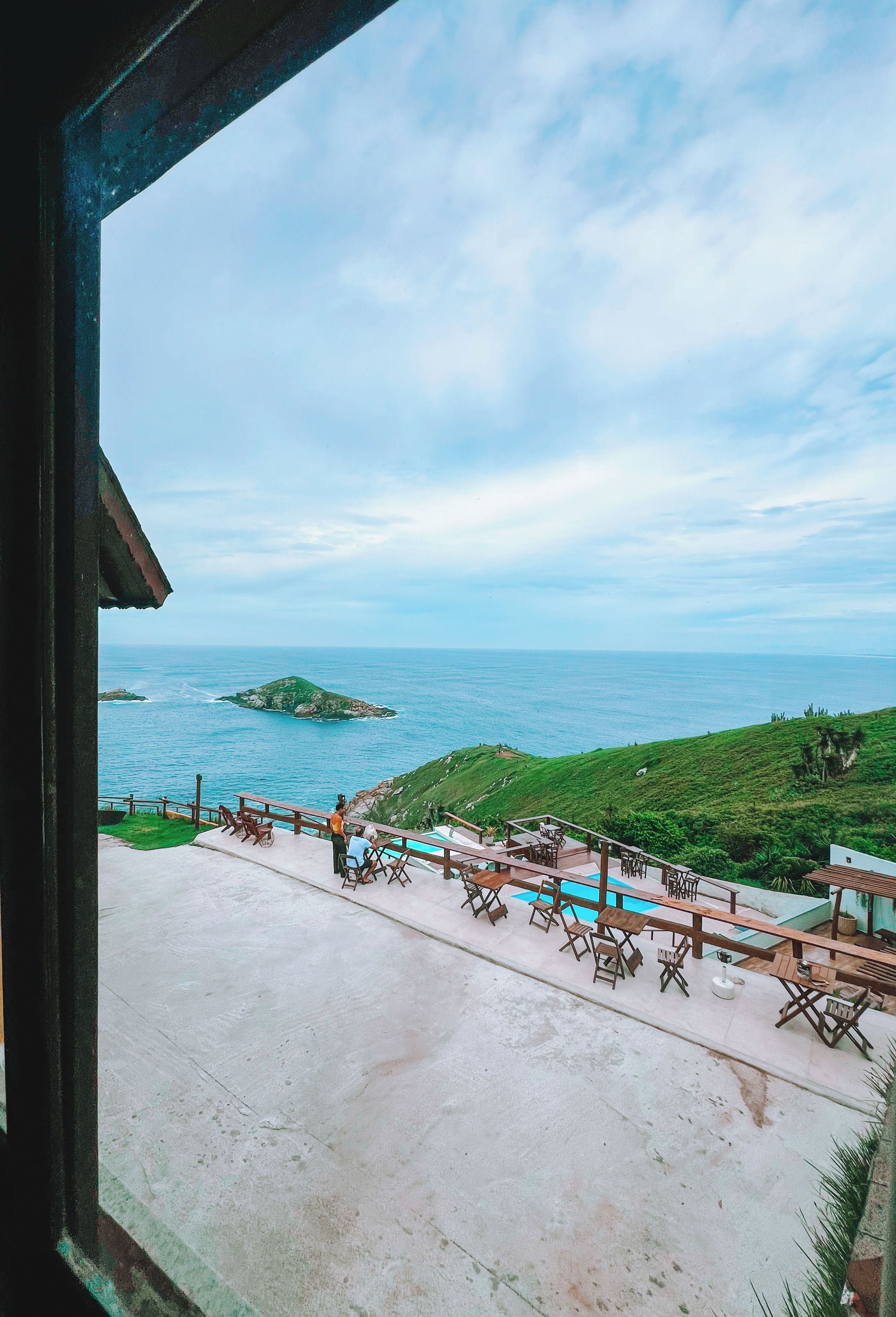 Vista de una zona costera con piscina y mobiliario exterior.