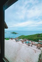 A view of a coastal area with a pool and outdoor seating.