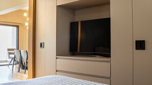 A modern bedroom with a large bed, built-in TV, and a minimalist design. - ICONIC SALONICA SUITE seafront (Thessaloniki)