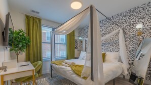 A bedroom with a four-poster bed, a desk with a chair, a potted plant, and a large mirror. - Opulence in Olive with Free Parking+ 2 Bath & Sleeps 8.✨20% OFF 7days✨ (City of Orange)