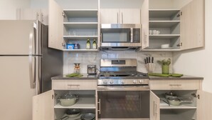 A modern kitchen with a stainless steel refrigerator, microwave, stove, and oven. - Opulence in Olive with Free Parking+ 2 Bath & Sleeps 8.✨20% OFF 7days✨ (City of Orange)