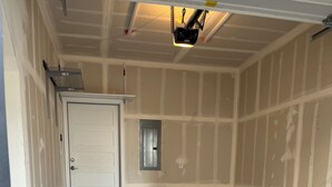 A garage with a concrete floor, a white door, and a small window. - Highlands Home with Rocky Mountain Views! (Denver)