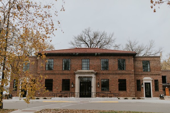 A brick building with a central entrance, multiple windows, and a red-tiled roof.
