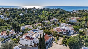 A coastal residential area with white buildings, a swimming pool, and a view of the sea. - Villa Casa Fatinha by Villa Plus (Praia do Carvoeiro)